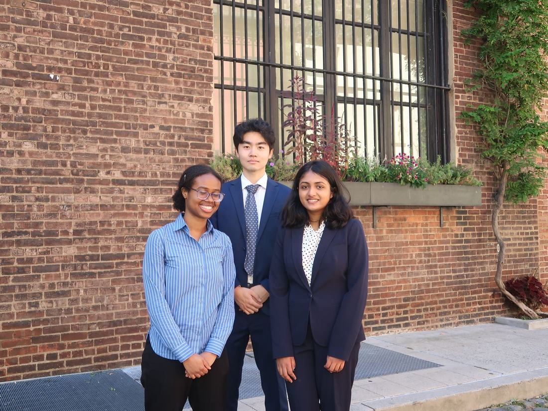 Three members of the Applied Research Team standing together outside