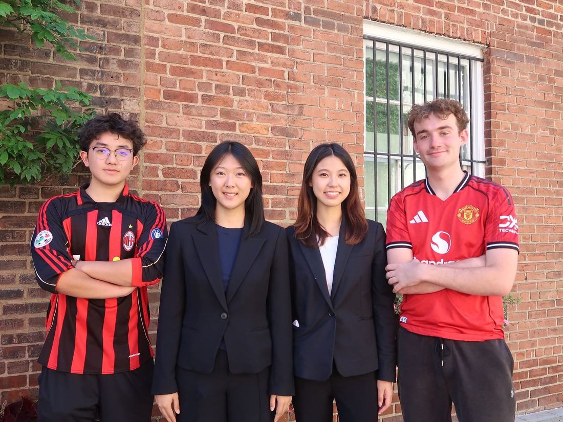 Members of the Workshop and Mentorship (WAM) team posing together against a brick wall